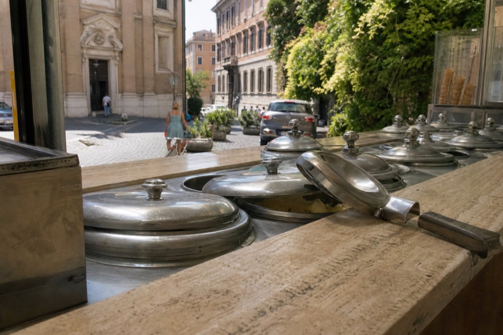 Rows of covered metal gelato tins in a Roman gelateria