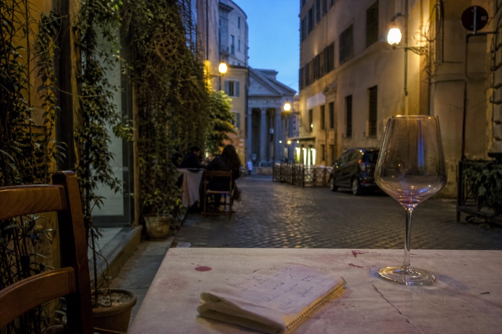 A handwritten Roman restaurant bill on a table