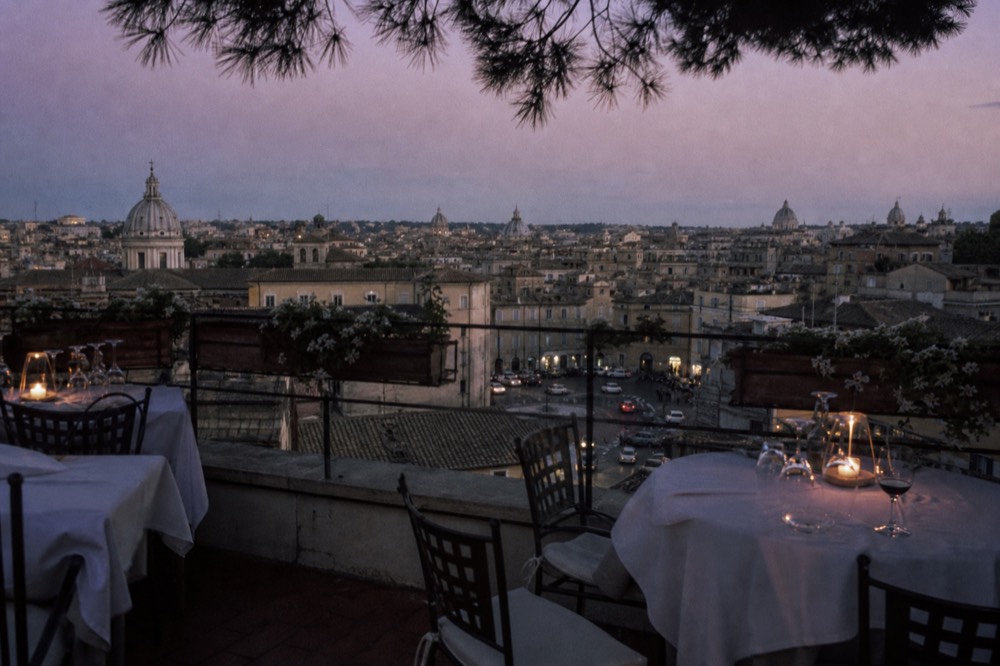 City lights seen from a rooftop dining terrace at dusk