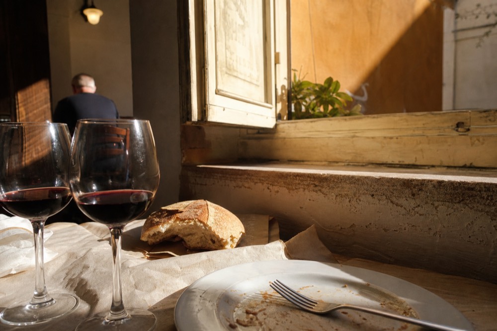 Traditional Roman trattoria table with wine glasses and bread