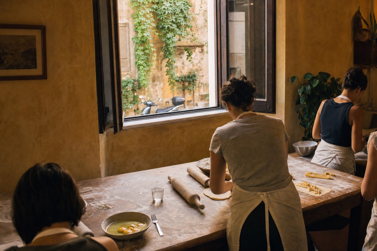 A pasta-making class table in Rome with flour, eggs and rolling pins