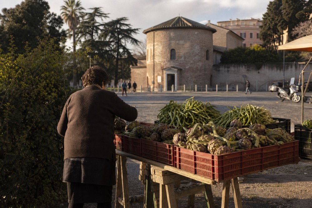 A market stall with fresh Roman vegetables and artichokes in crates