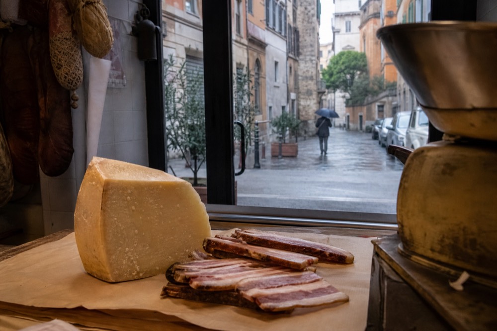 Pecorino romano cheese and guanciale on a deli counter in Rome
