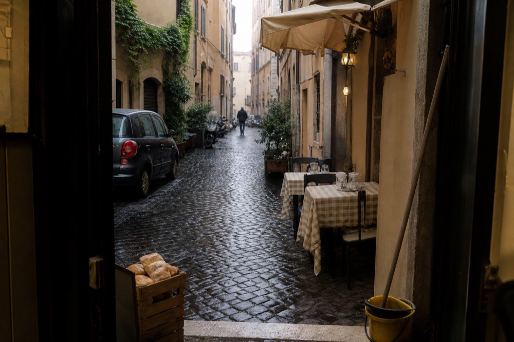 A quiet alley off Piazza Navona with a small trattoria sign